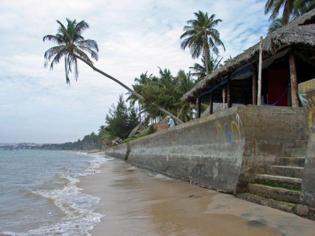 Morze południowo-chińskie i betonowy mur przy plaży, Mui Ne