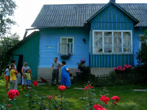 Na tle czerwonych róż stara zamieszkała nadal chata #rodzina #dom #domek #zabytek #StaraChata #chatka #ogród #kwiaty